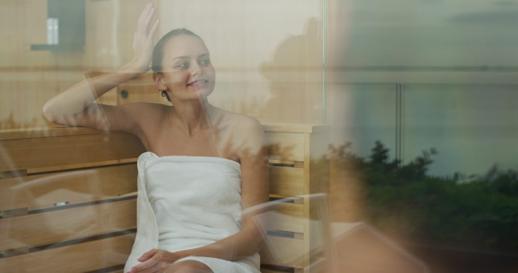 happy woman enjoying a hot sauna steam room